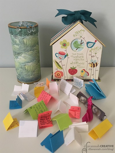 Folded pieces of colored paper in front of a box used in a gratitude practice